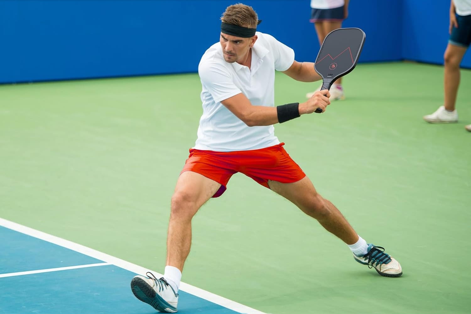 A player driving a backhand on an outdoor court with a Precision Pro carbon fiber paddle